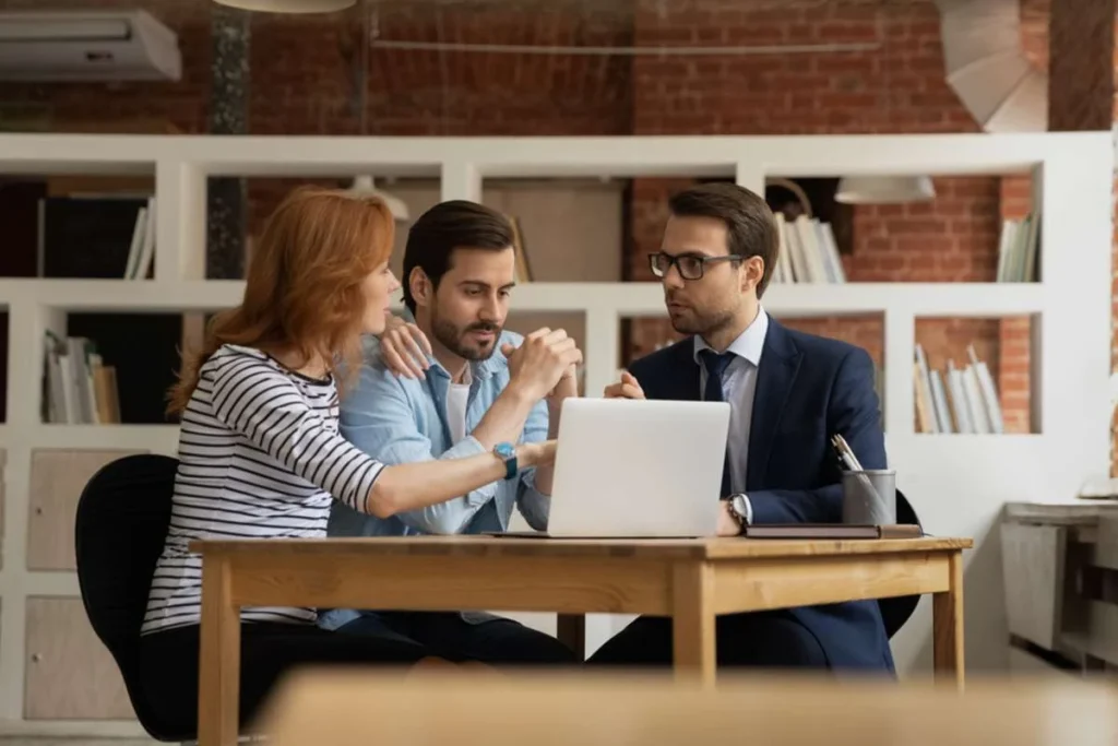 young couple talking with property manager during the tenant screening process